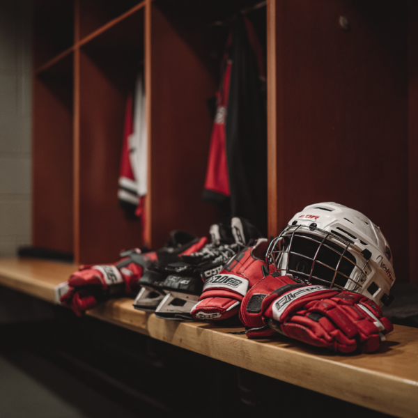 clean hockey gear laid out in a professional locker room